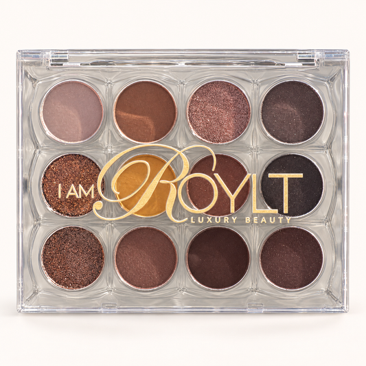 IAMROYLT GlamPalette with 12 eyeshadow pans in a clear compact with gold branding on a warm ivory background.